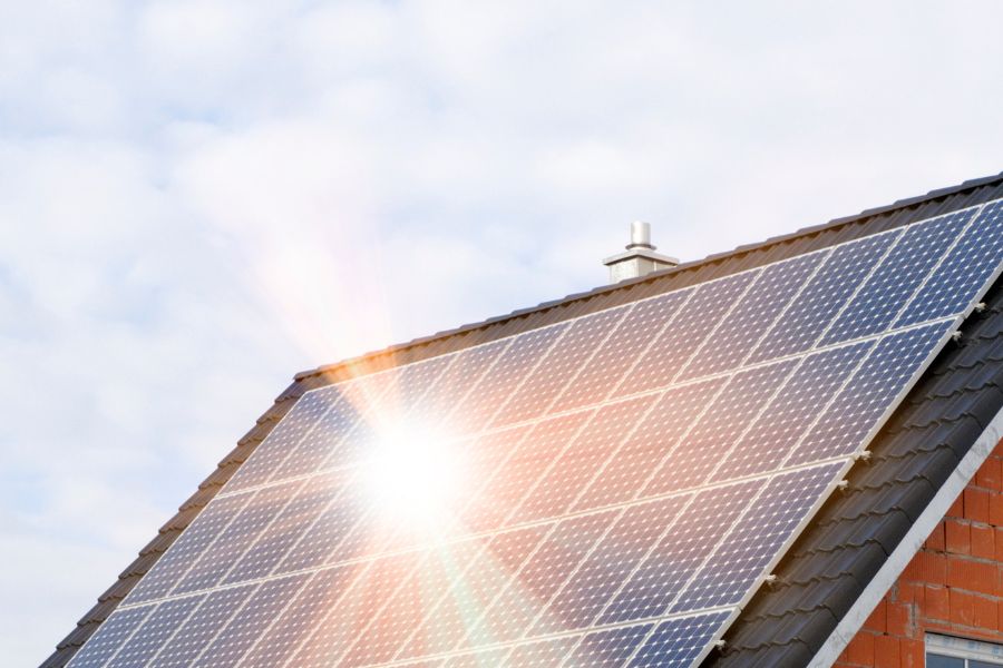 Sun reflects in solar panels on house roof